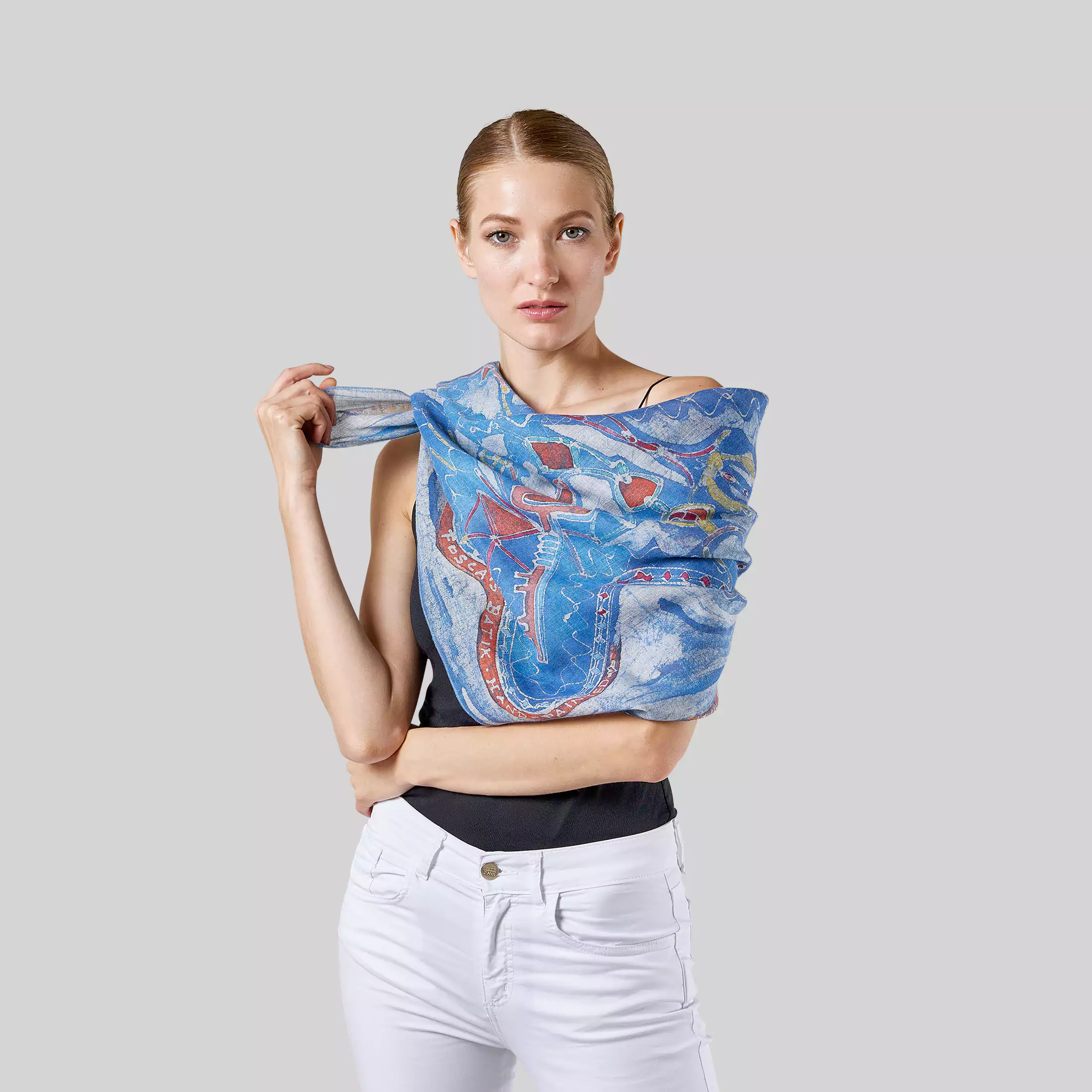 Una modella posa avvolta nella sciarpa in cotone dipinto a mano "Equilibrismi" di Fosca's Batik.
