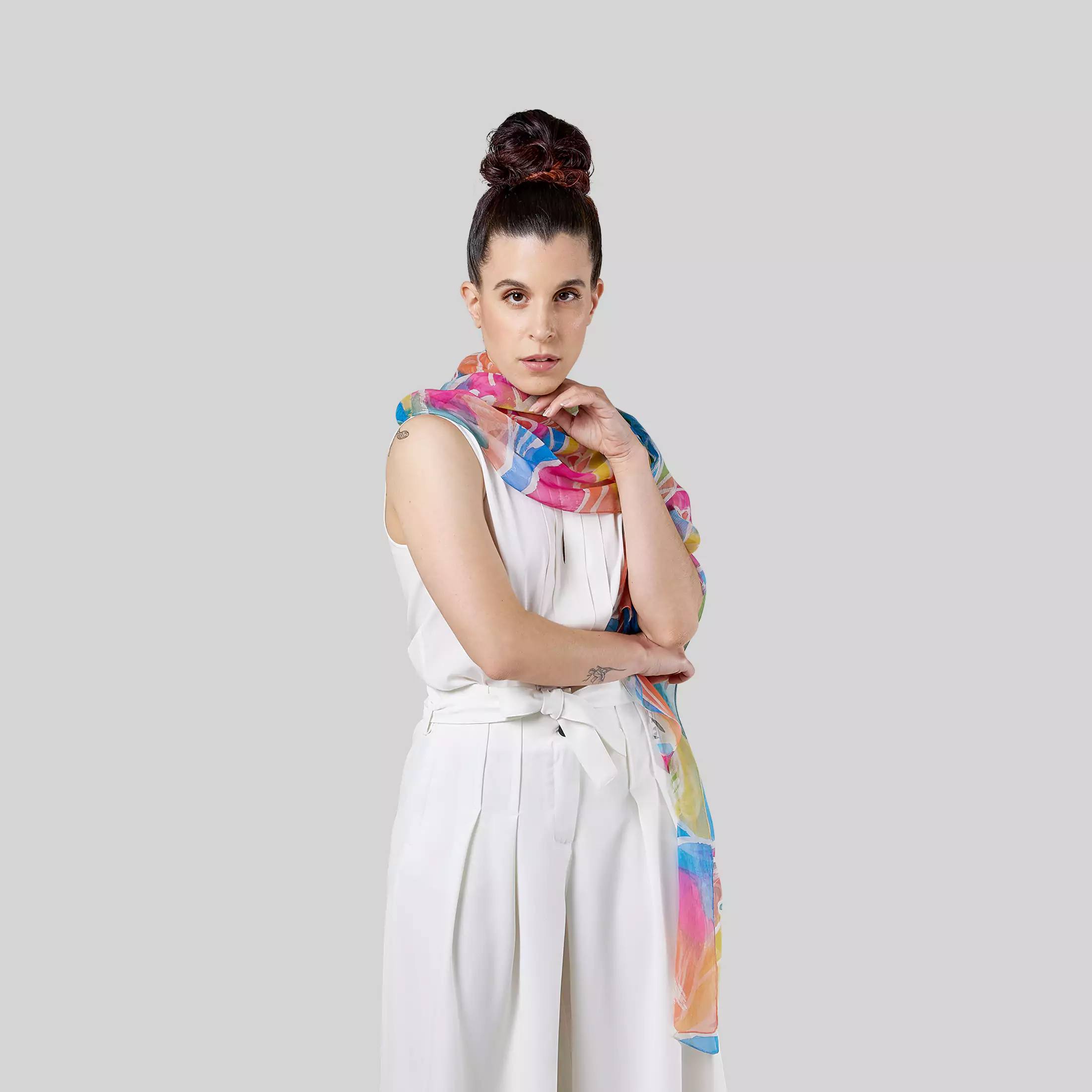 Una modella posa indossando intorno al collo la stola da donna in chiffon di seta dipinta a mano “Energising flowers” di Fosca’s Batik